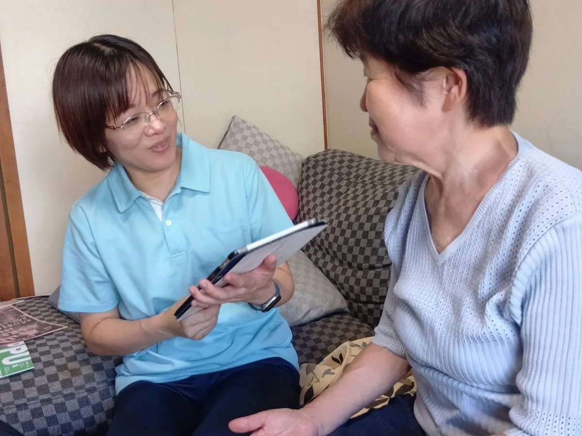 利用者の方と話をしながら訪問看護を行うスタッフ